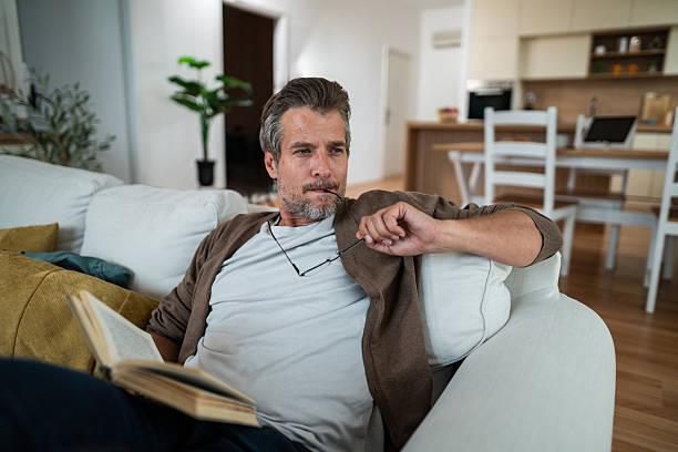 Man relaxing on sofa, contemplating life during a break