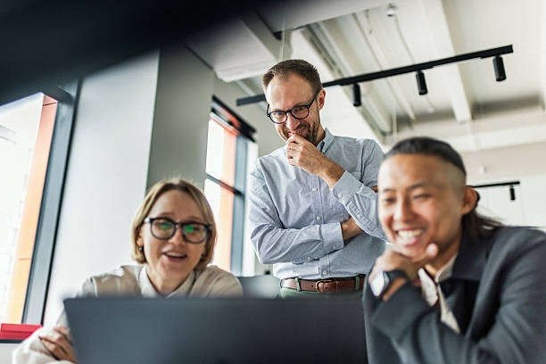 istock Three professionals collaborate around a laptop in a bright office, sharing ideas and planning a project together. 2240988302