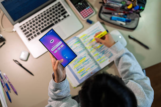 istock Teenage girl using AI chatbot on smartphone while studying at desk 2240990115