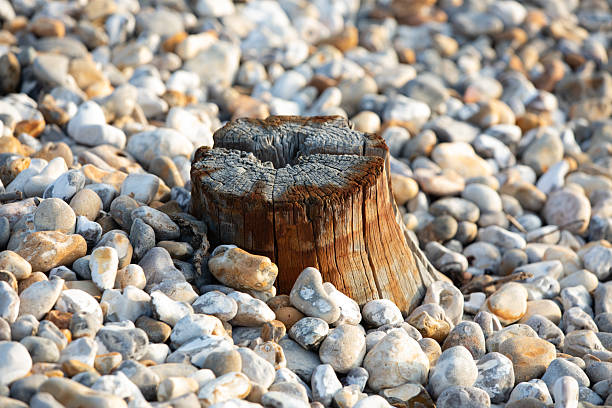 The rust coloured marks of metal parts that were attached to the post and discoloured timber match the tone of the pebbles.