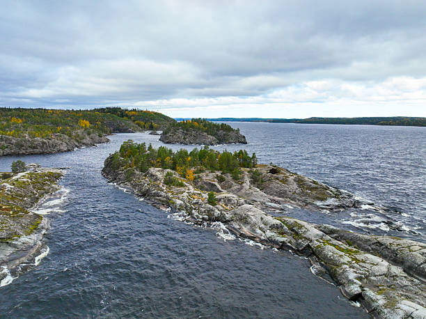 istock Choppy water flowing around two rocky, forested islands 2240990363