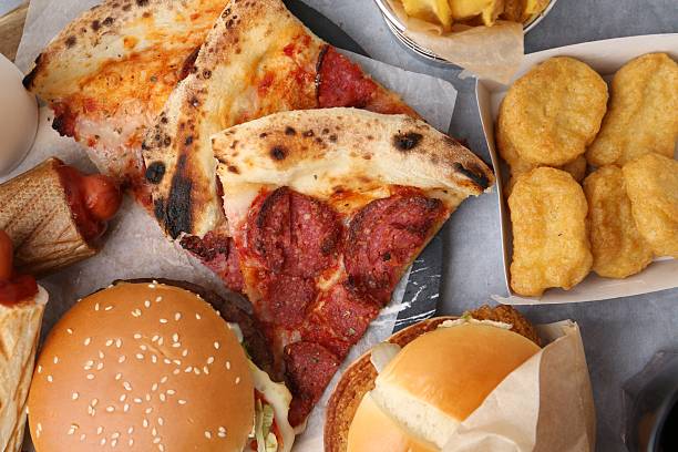Different delicious fast food on grey table, flat lay
