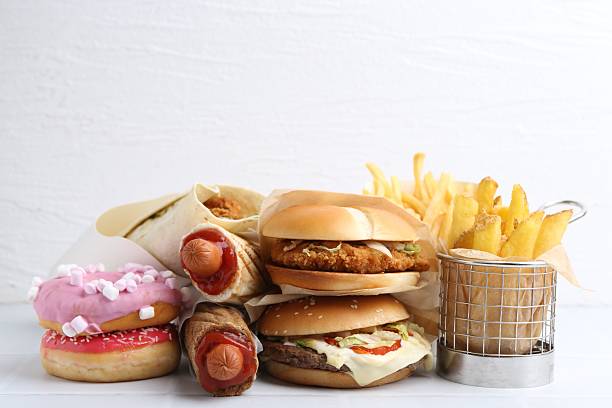 istock Different delicious fast food on white table, closeup 2240990387