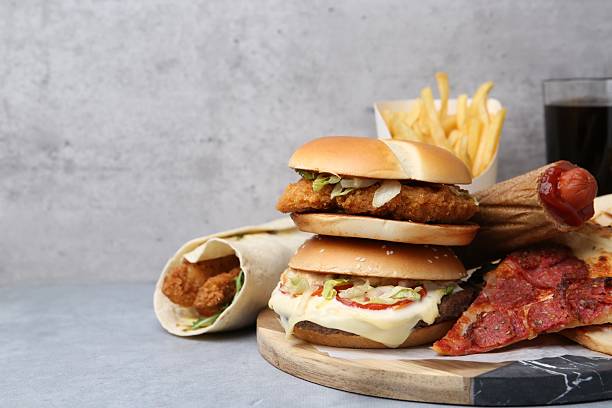Different delicious fast food and soda drink on grey table, closeup. Space for text
