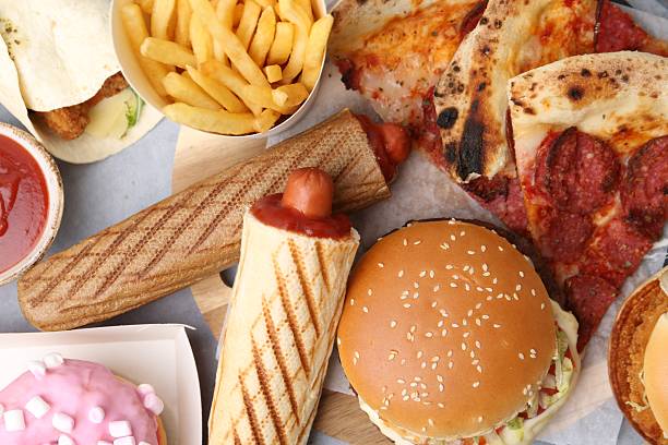 istock Different delicious fast food on grey table, flat lay 2240990444