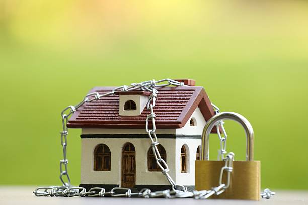 istock Home security. House model, chain and padlock on white table outdoors, closeup 2240990854