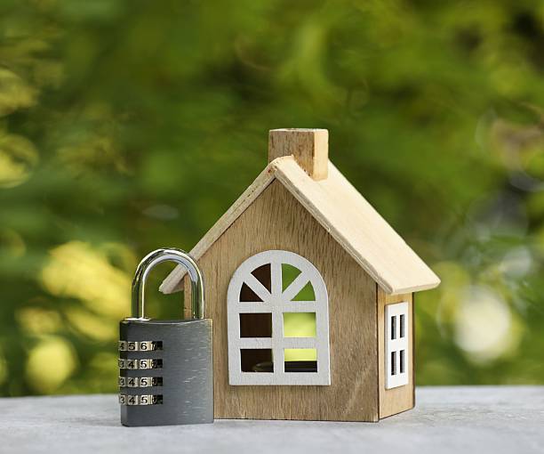 istock Home security. House model and padlock on light grey table outdoors, closeup 2240991012