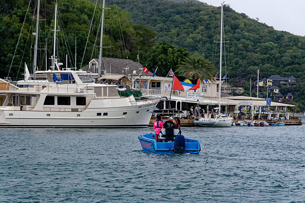 Nelson's Harbor - a boat with flags marking the finish live to 'The World's Toughest Row' in English Harbor.