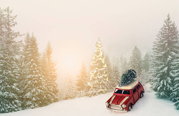 Winter holidays concept with retro car transporting Christmas tree