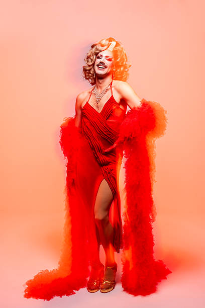 istock Joyful Drag Queen Exuding Happiness in Vibrant Orange Attire in Studio Setting 2240994714