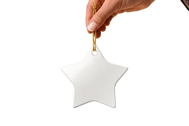 Hand holding Christmas star ceramic ornament or decoration with golden string mockup isolated on a white background. High resolution. Mockup, template ready for your design.