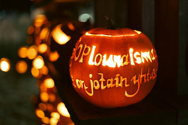 istock Carved glowing Halloween pumpkins with candles in dark night. 2241001521