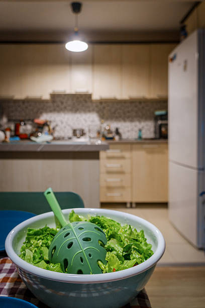Freshly prepared green salad in a bowl with a leaf-shaped server, ready for a healthy meal