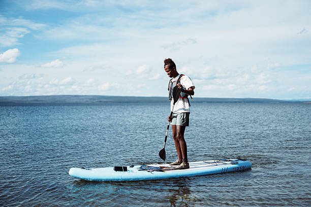 istock Young Black man paddle boarding on lake 2241007244