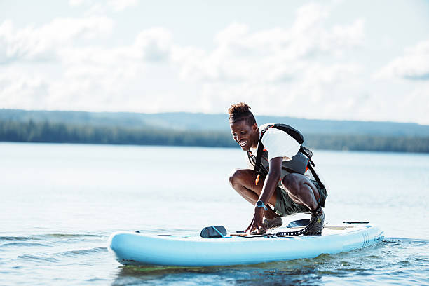 Young man paddle boarding on lake in summer