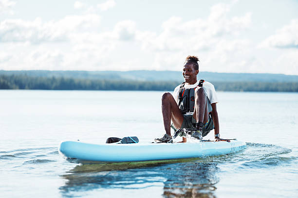 istock Young man paddle boarding on lake in summer 2241007338