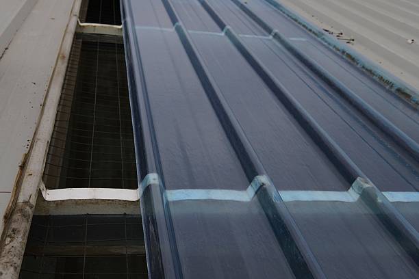 istock Translucent corrugated roofing panel.A roof covered with translucent blue corrugated roofing panels against a metal roofing section. 2241012035