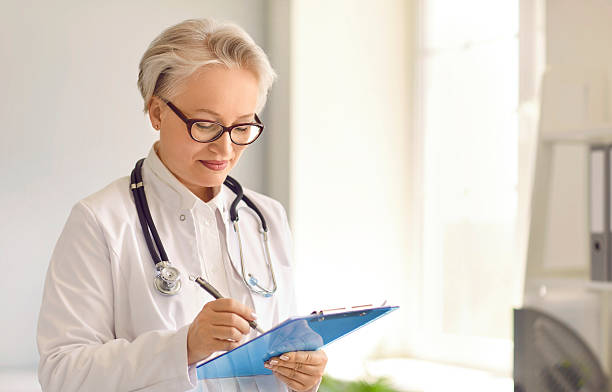istock Female doctor holding a clipboard and taking notes in medical forms and documents 2241012348