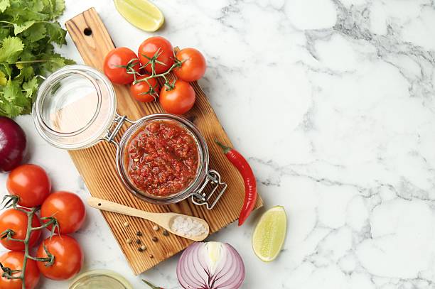 istock Spicy salsa and ingredients on white marble table, flat lay. Space for text 2241013533