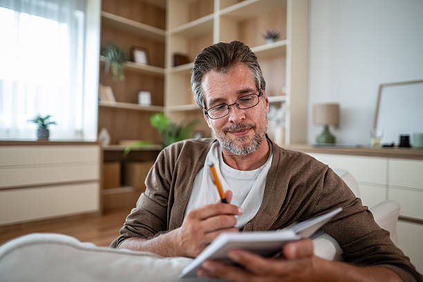 istock Man writing in notebook enjoying creative journaling at home 2241013858