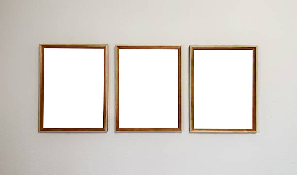 istock Three empty wooden frames hang on a textured off-white wall, ready for artwork or photos.Concept of: Blank display. 2241015049