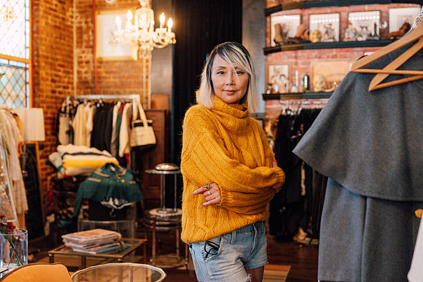 A stylish shopper takes a closer look at garments inside a well-lit and inviting clothing store.