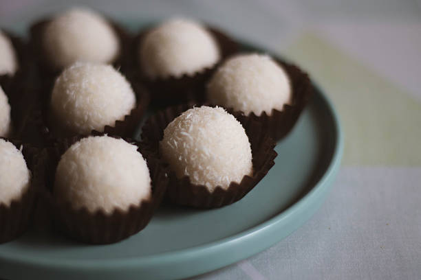 Close-up of traditional Catalan coconut panellets, typical Spanish sweets made with grated coconut and marzipan. Homemade dessert for All Saints Day in Catalonia, Spain.