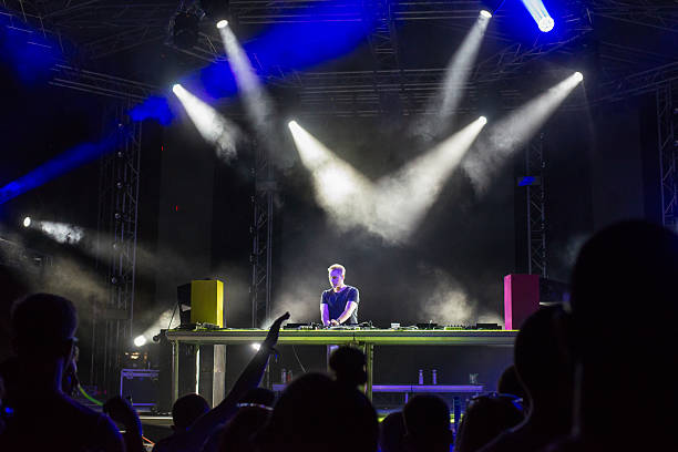 istock Dj playing techno music on the stage during night concert 2241023633