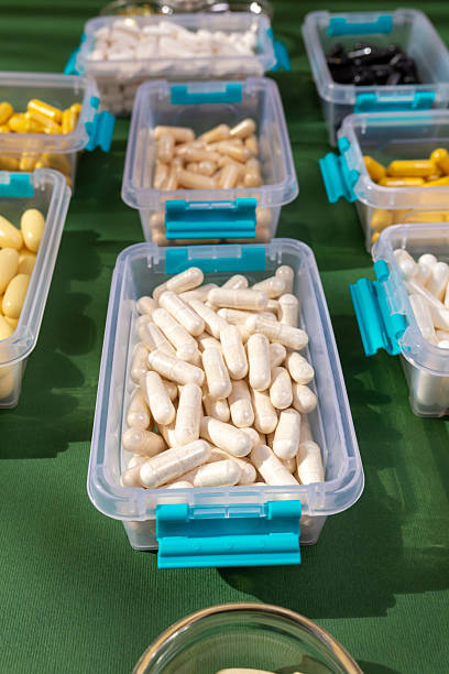 istock Vitamins, minerals and dietary supplements in containers from above on green background in sunlight. Assortments of many colored pills, tablets, capsules and food supplements. 2241024521