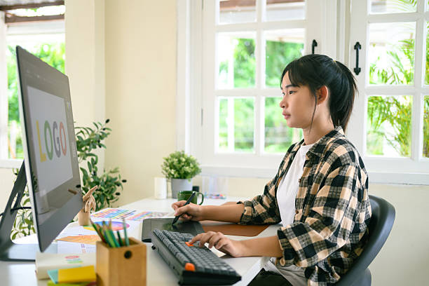istock Focused graphic designer working on computer with color palette and tablet in bright modern creative workspace 2241024687