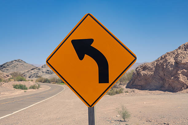 istock Orange diamond road sign indicating a sharp curve to the left 2241026069