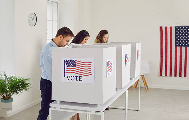 istock Concentrated people are reading information on election ballots before casting their votes. 2241028252