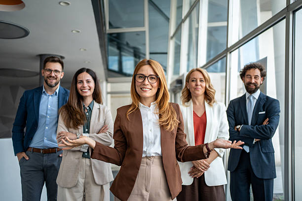 istock Business team standing in modern office building with confident leader 2241029558