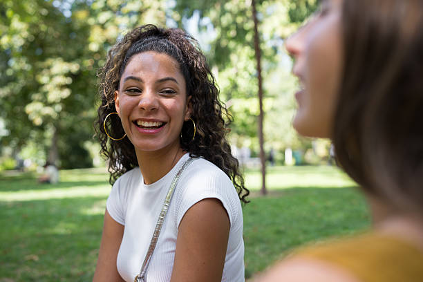 istock Young woman smiling and laughing in park 2241032678