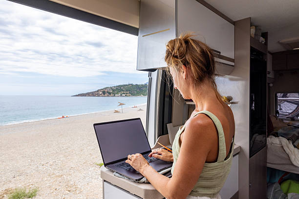 istock Woman Working Remotely in Camper Van with Sea View 2241032714