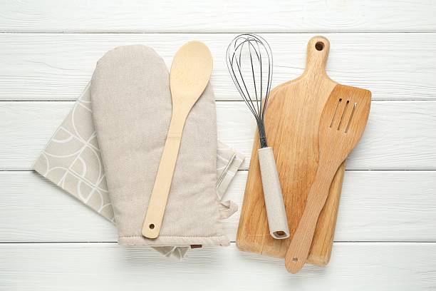 istock Oven glove and other kitchen utensils on white wooden table, flat lay 2241033185