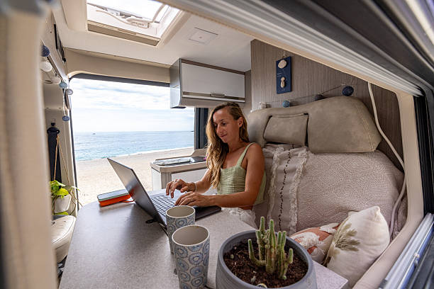 istock Woman Working Remotely in Camper Van with Sea View 2241033424