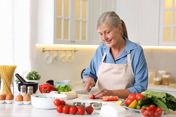 istock Senior woman cooking at white marble table in kitchen 2241035830