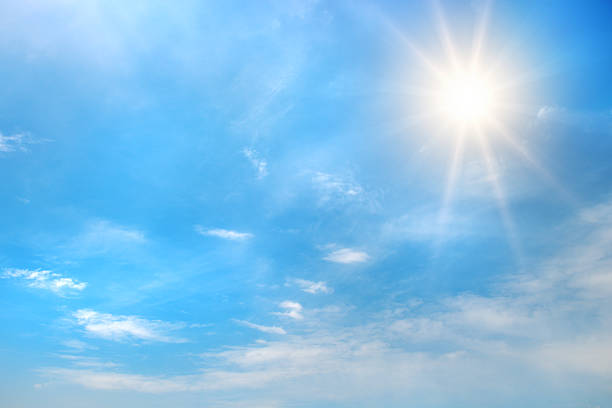 istock Bright blue sky with shining sun in upper corner and scattered white clouds illuminated by sun rays creating glowing daytime atmosphere with copy space 2241036162