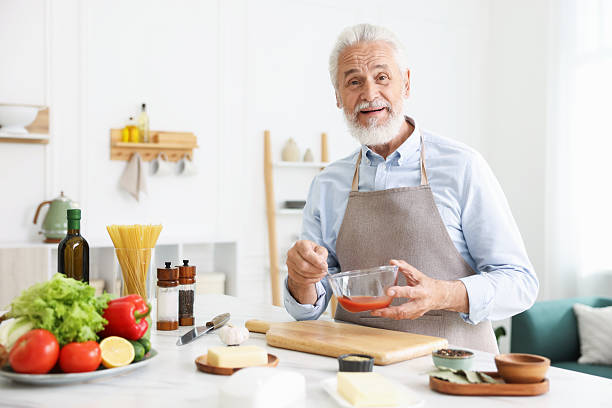 istock Elderly man cooking at white marble table in kitchen 2241036223