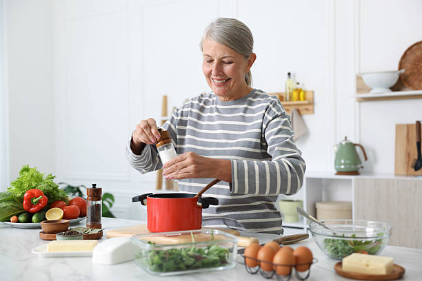 istock Senior woman cooking at white marble table in kitchen 2241036844