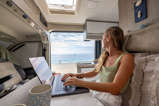 istock Woman Working Remotely in Camper Van with Sea View 2241040219