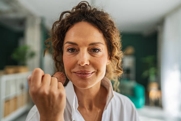 istock Woman applying blush using makeup brush during beauty routine 2241047926