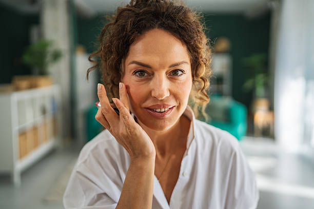 istock Woman applying lipstick during her morning self-care routine 2241048253