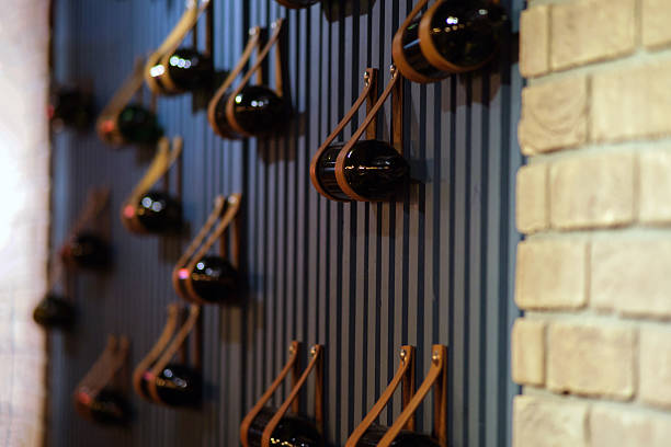 istock Minimalist brown leather wine holder storing bottles on a striped blue wall. Modern interior design for restaurant or bar display. 2241048971
