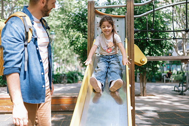 istock Caring father helping his excited daughter slide safely 2241049803