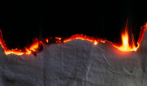istock burning paper, glowing edge of paper on a black background 2241051782