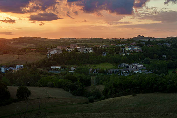 istock Sunset over Tuscan village and fields, warm sky tones, rolling hills, tranquil evening landscape 2241055699
