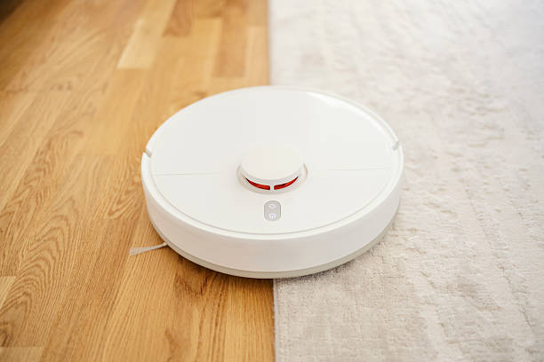 istock Robot vacuum cleaning wooden floor and carpet 2241057516