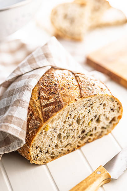 Photo of sliced baked sourdough bread on white table.